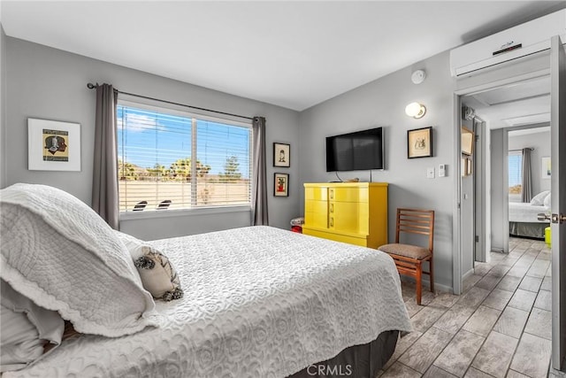 bedroom with baseboards and an AC wall unit