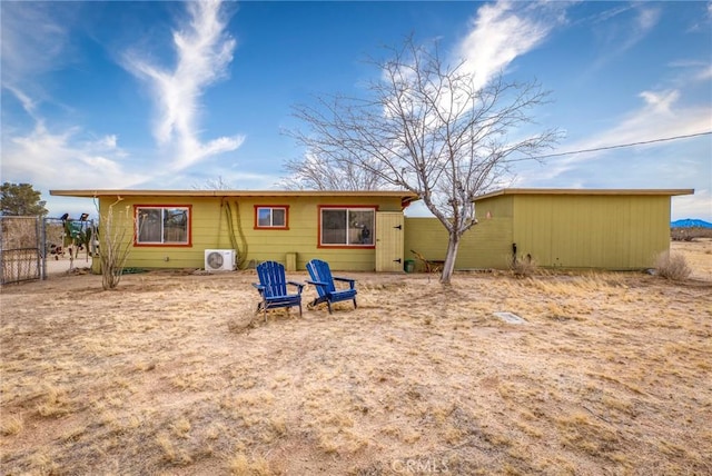 rear view of property with ac unit and fence