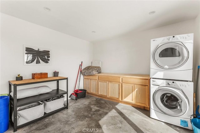 washroom with cabinet space and stacked washing maching and dryer