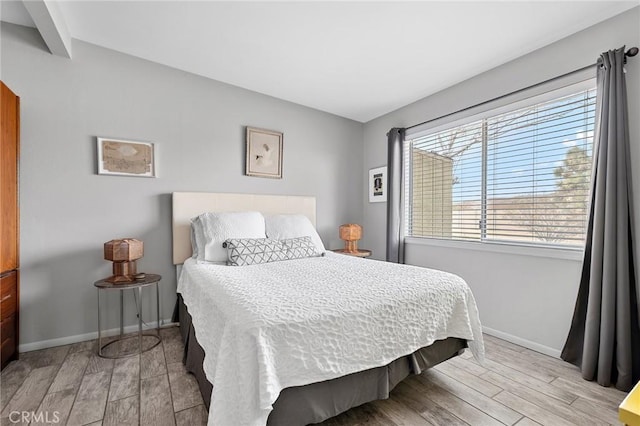 bedroom with light wood-style flooring and baseboards