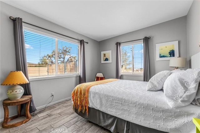 bedroom featuring light wood-style floors and baseboards