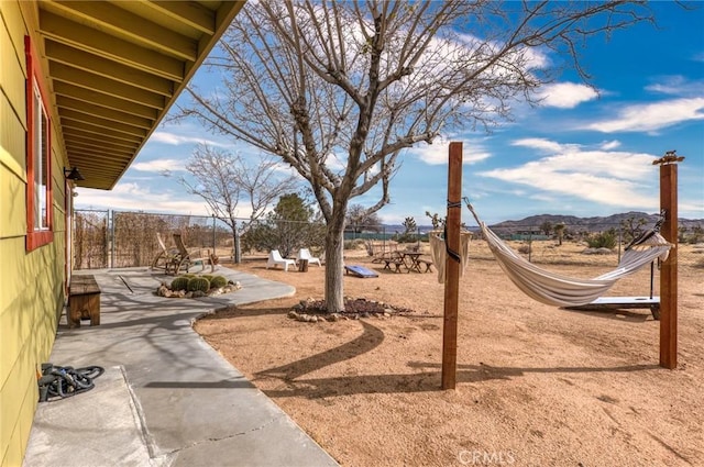 view of yard with a patio area, fence, and a mountain view