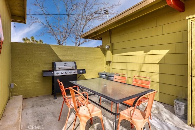 view of patio with fence, outdoor dining area, and area for grilling