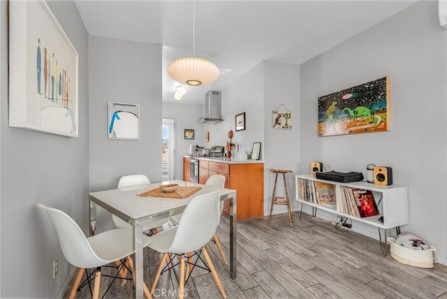 dining space featuring light wood-style floors and baseboards