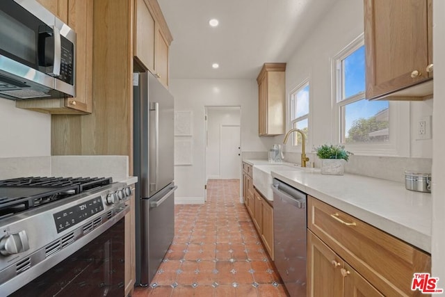 kitchen with light tile patterned floors, appliances with stainless steel finishes, and sink