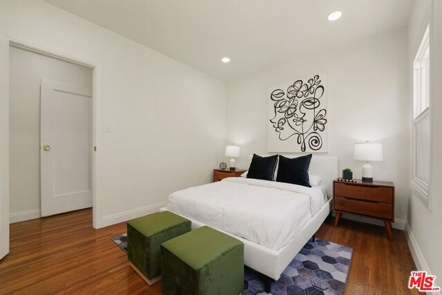 bedroom with dark hardwood / wood-style flooring