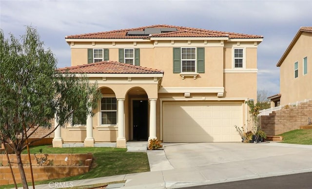 mediterranean / spanish home with solar panels and a garage