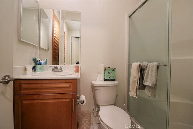 bathroom featuring walk in shower, vanity, and toilet