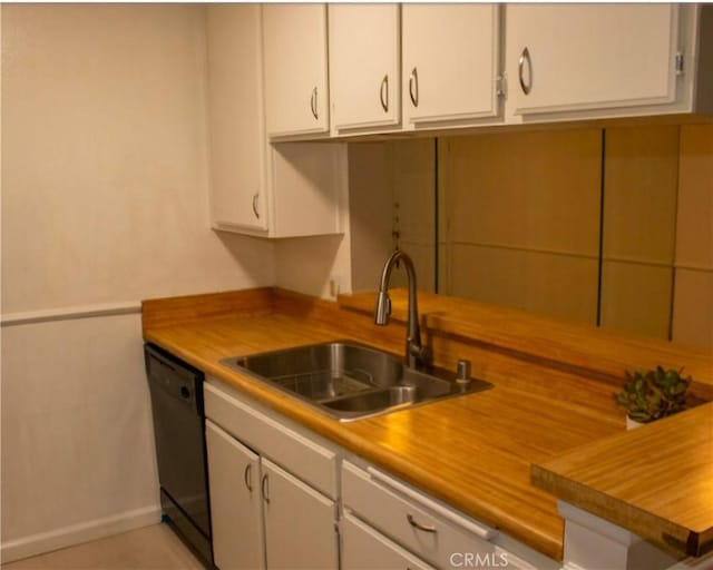 kitchen with sink, white cabinetry, black dishwasher, and butcher block countertops