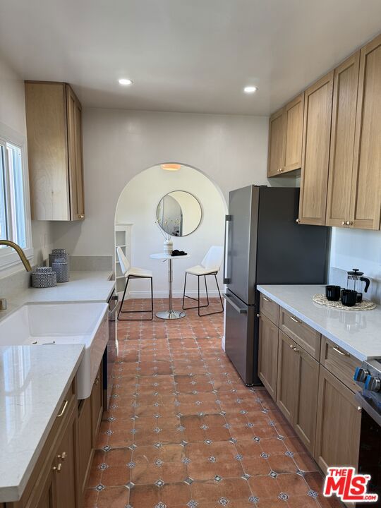 kitchen with stainless steel appliances, tile patterned floors, and sink