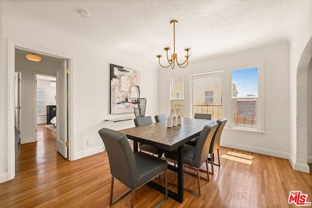 dining area featuring a textured ceiling, a chandelier, and hardwood / wood-style flooring