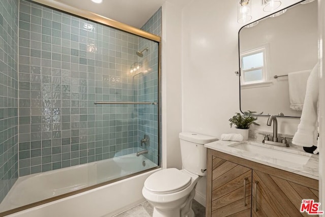 full bathroom with combined bath / shower with glass door, vanity, and toilet