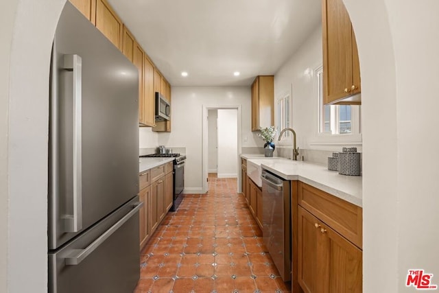 kitchen with sink, stainless steel appliances, and tile patterned flooring