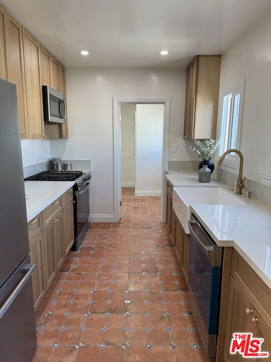 kitchen with light tile patterned floors, sink, and stainless steel appliances