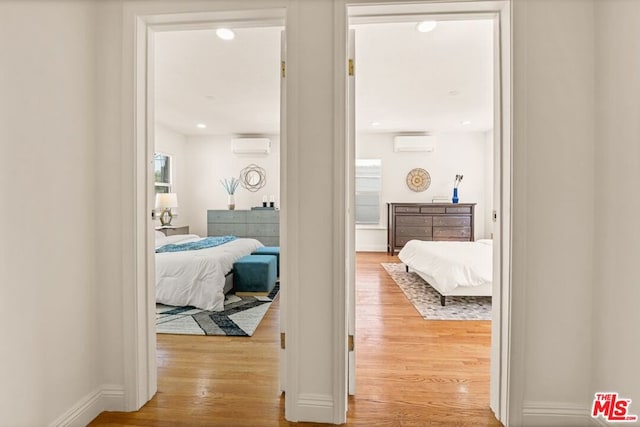 hall featuring light hardwood / wood-style flooring and a wall mounted AC