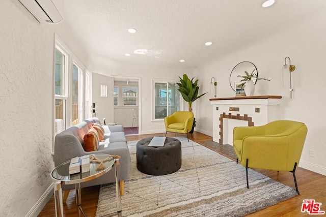 sitting room featuring a wall unit AC and hardwood / wood-style flooring