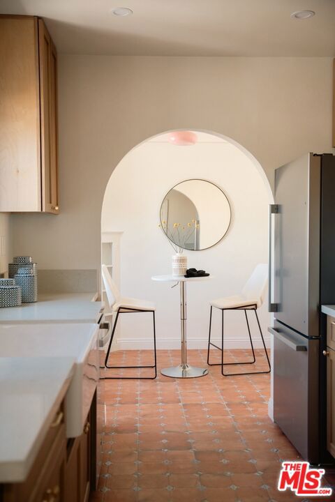 kitchen featuring light tile patterned flooring and stainless steel refrigerator