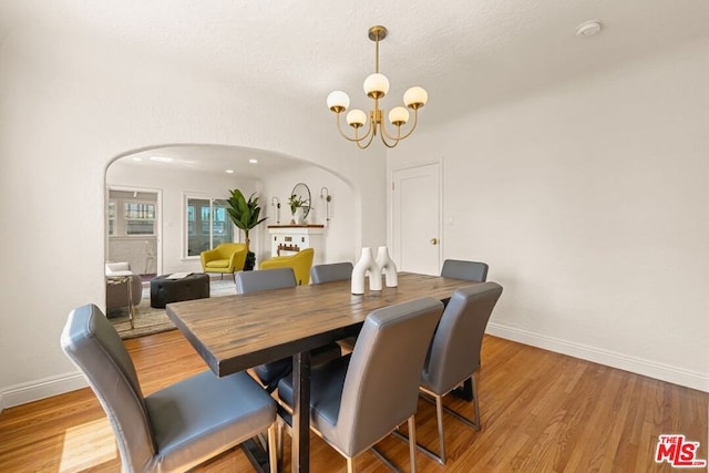 dining room with light hardwood / wood-style floors and a notable chandelier