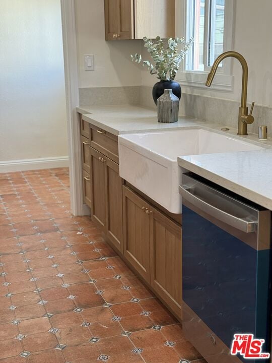 kitchen featuring sink, stainless steel dishwasher, and tile patterned flooring