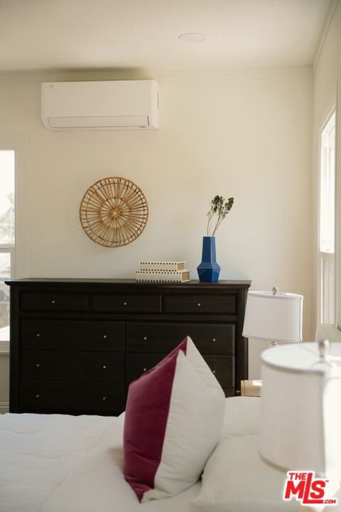 bedroom with multiple windows and a wall mounted air conditioner