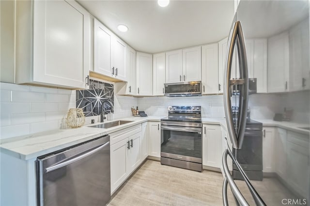 kitchen with sink, white cabinets, and appliances with stainless steel finishes