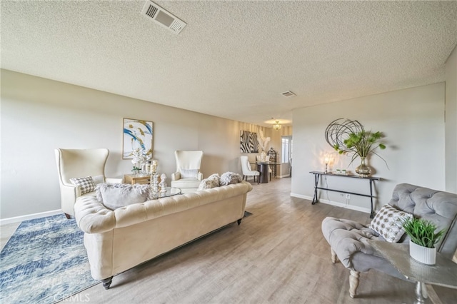 living room with a textured ceiling and hardwood / wood-style floors