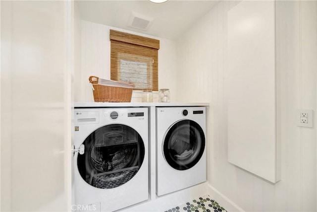 clothes washing area with washing machine and dryer and tile patterned floors