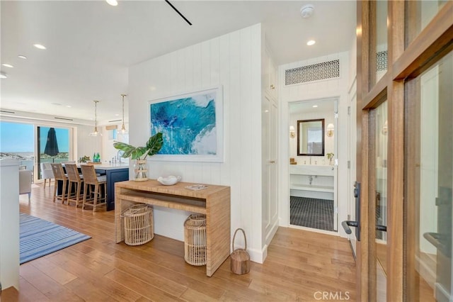 corridor featuring wood walls and light hardwood / wood-style flooring