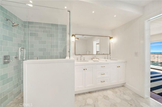 bathroom featuring a shower with shower door and vanity