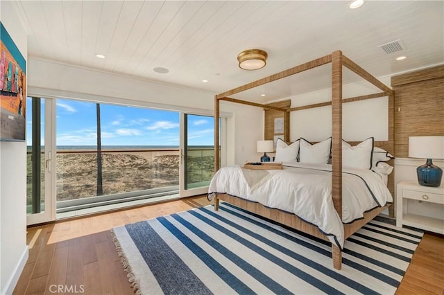 bedroom with light hardwood / wood-style flooring, crown molding, and wooden ceiling