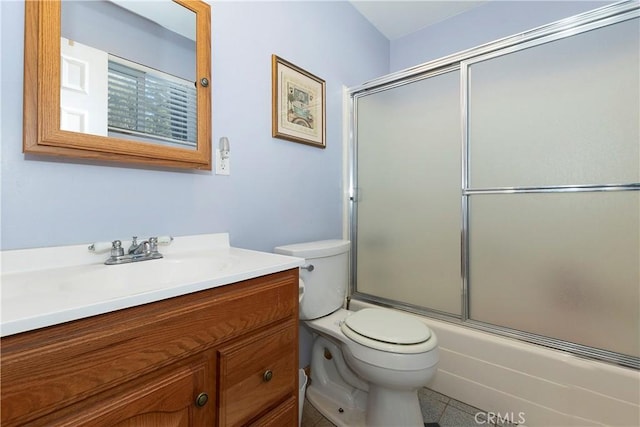 full bathroom with combined bath / shower with glass door, vanity, toilet, and tile patterned flooring