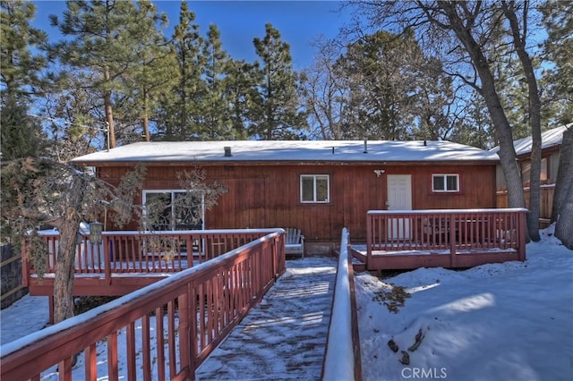 snow covered house with a wooden deck