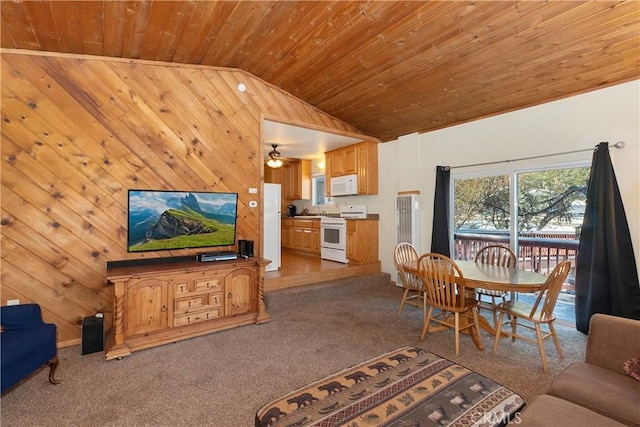 carpeted living room with lofted ceiling, wood ceiling, sink, wood walls, and ceiling fan