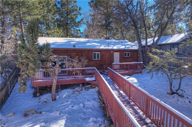 snow covered house with a deck