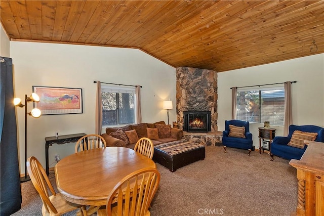 carpeted dining room featuring lofted ceiling, a healthy amount of sunlight, a fireplace, and wood ceiling