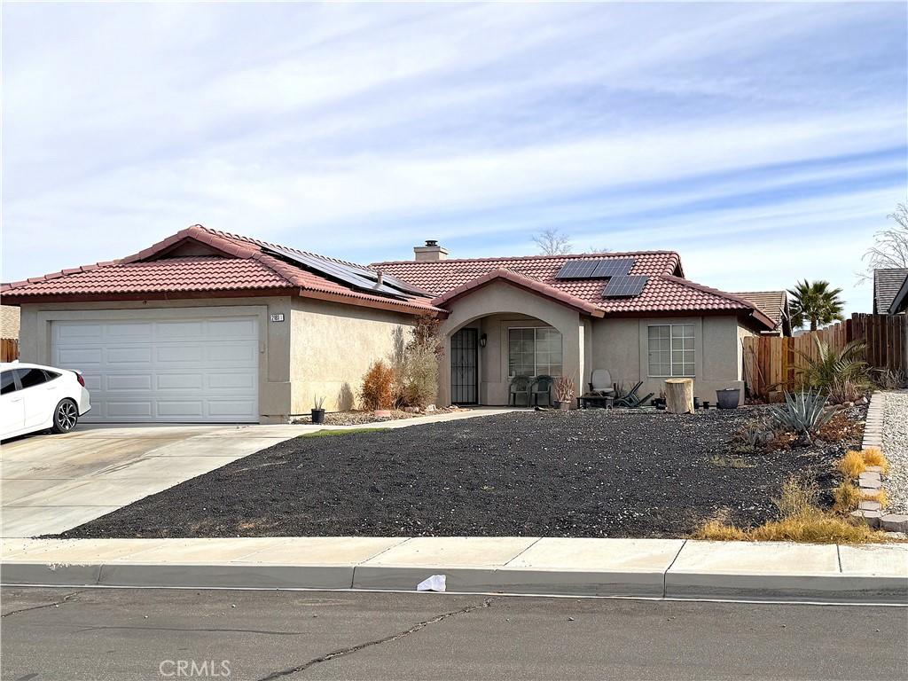 view of front of property with a garage and solar panels