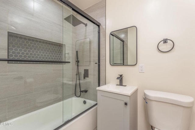 full bathroom featuring toilet, vanity, and bath / shower combo with glass door