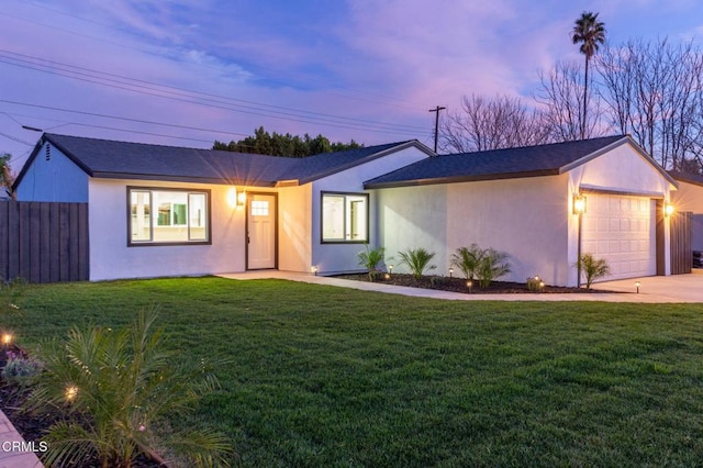 ranch-style home featuring a garage and a lawn