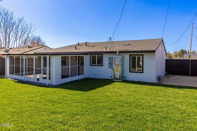 back of property featuring a sunroom and a lawn