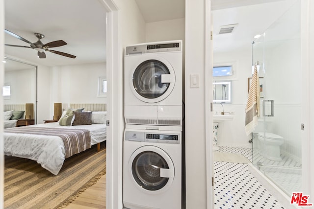 laundry room with stacked washing maching and dryer and ceiling fan