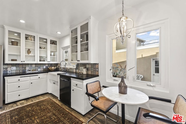 kitchen featuring white cabinetry, black dishwasher, decorative backsplash, hanging light fixtures, and sink