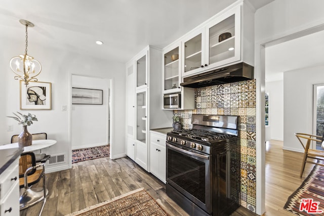 kitchen featuring an inviting chandelier, white cabinetry, appliances with stainless steel finishes, tasteful backsplash, and dark wood-type flooring