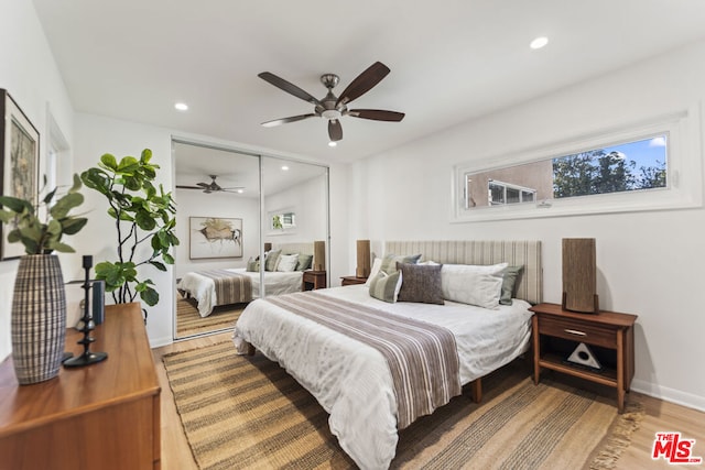 bedroom with ceiling fan, wood-type flooring, and a closet