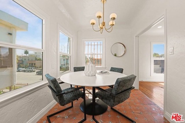 dining area with dark tile patterned floors and a notable chandelier