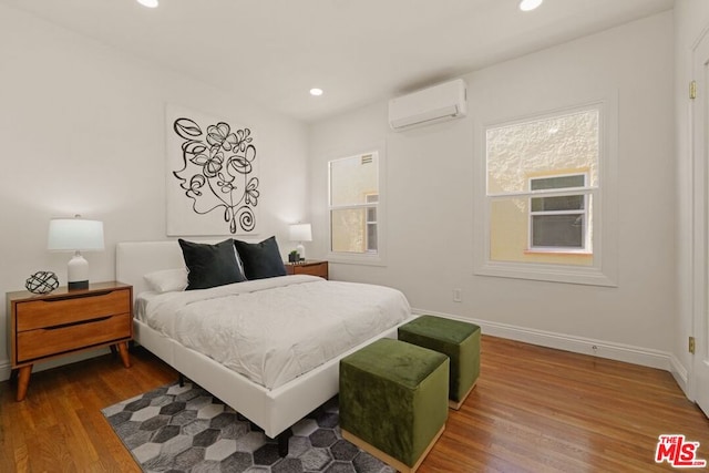 bedroom with hardwood / wood-style flooring and a wall mounted air conditioner