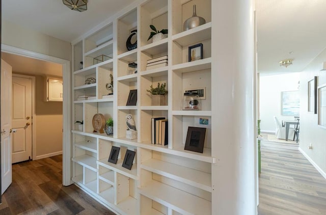 hallway with built in features and dark hardwood / wood-style floors