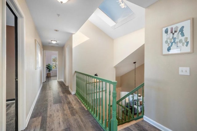 corridor featuring vaulted ceiling with skylight and dark hardwood / wood-style floors