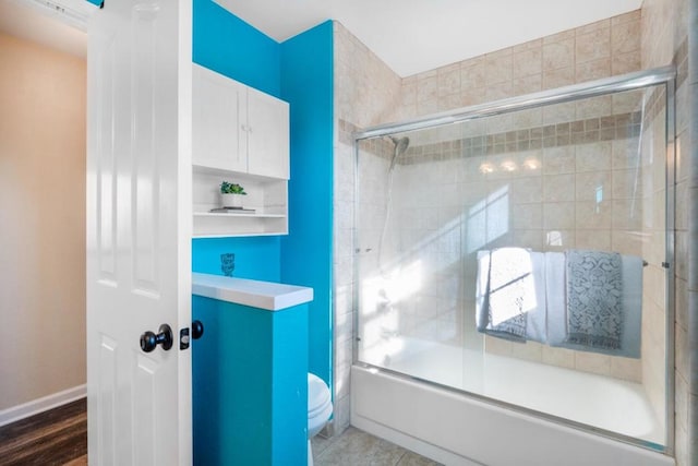 bathroom with toilet, hardwood / wood-style flooring, and enclosed tub / shower combo