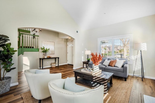 living room featuring high vaulted ceiling, wood-type flooring, and an inviting chandelier