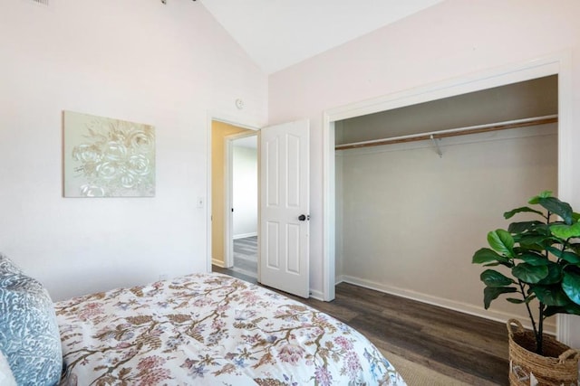 bedroom featuring dark wood-type flooring, high vaulted ceiling, and a closet